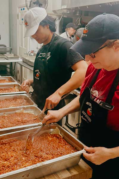 Kitchen Volunteers spooning beans
